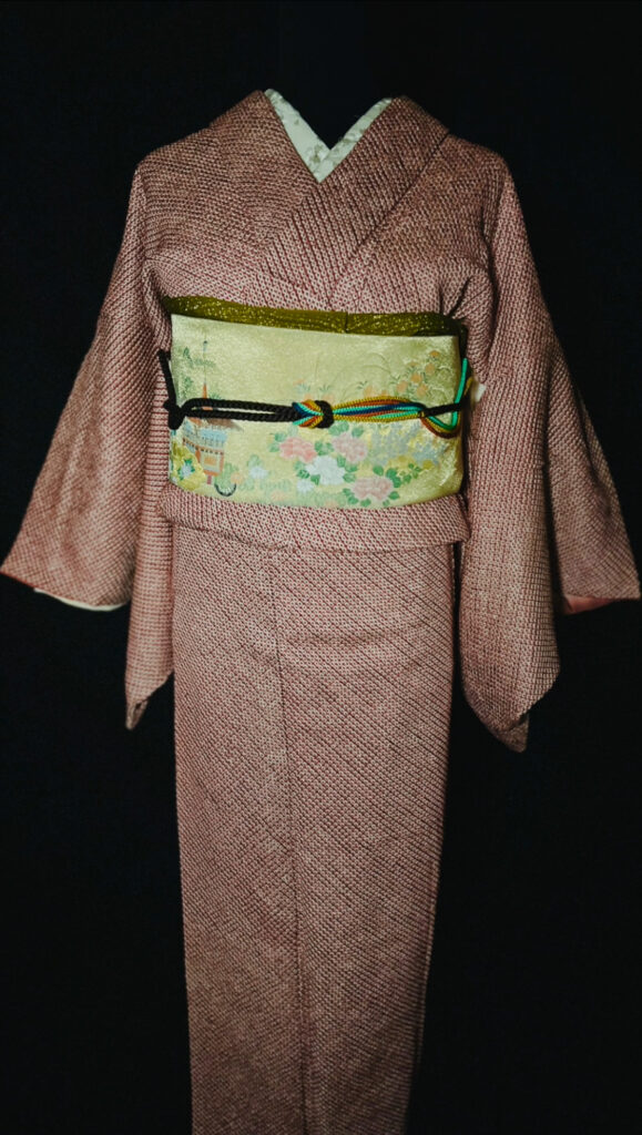 赤の総絞り小紋の全身コーディネート（淡い黄緑の袋帯、建物と草花文様、黒の帯締め）