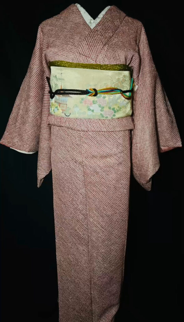 赤の総絞り小紋の全身コーディネート（淡い黄緑の袋帯、建物と草花文様、茶色の帯締め）