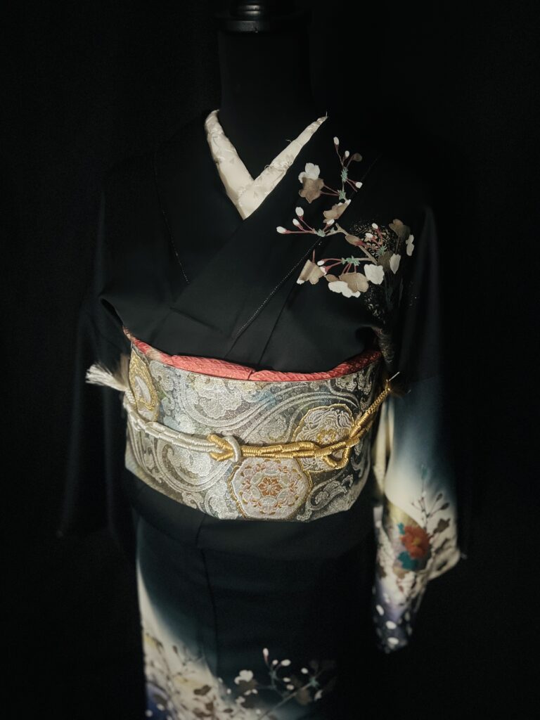 黒の桜柄訪問着の上半身と帯(胸元の桜、銀地の帯の意匠)