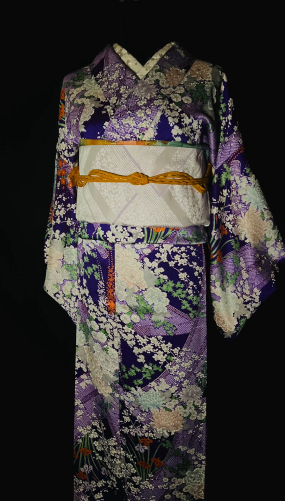 紫地の草花小紋(袷・正絹)の上半身。淡い名古屋帯とからし色の帯締めでまとめた帯まわりコーデ(家紋なし)