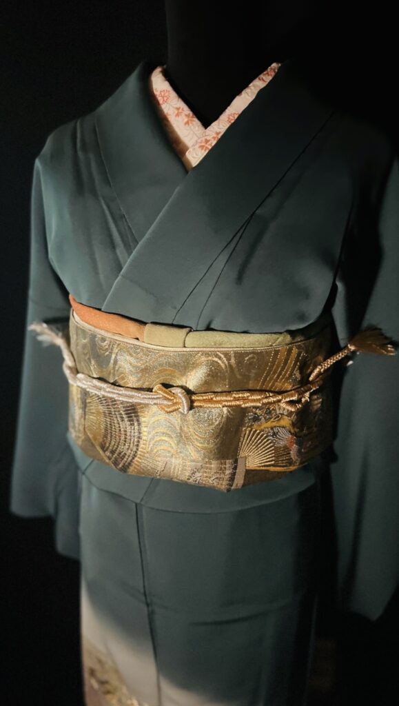 深緑の訪問着（袷）の上半身と帯まわり。金の扇文様の袋帯に、淡色の帯締めを合わせた上品なコーデ（家紋なし）