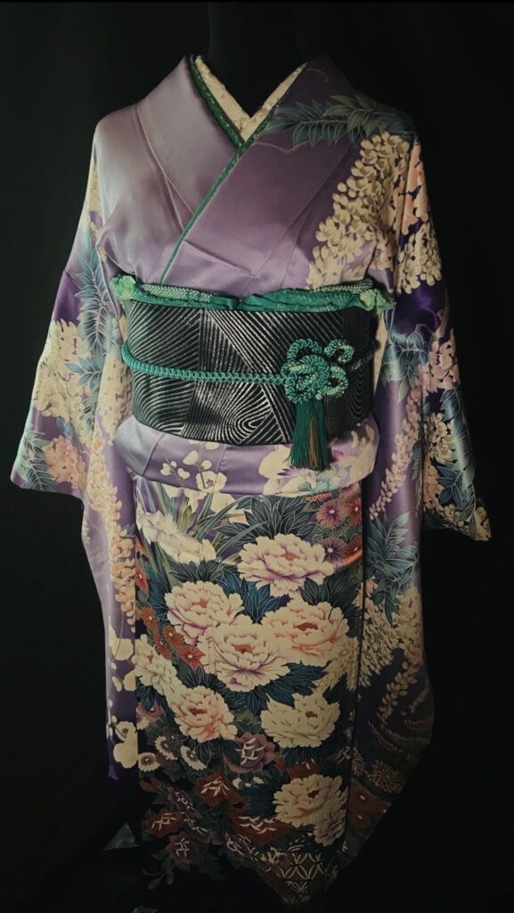 紫地の振袖に花が大きく描かれた華やかな着物の全身写真