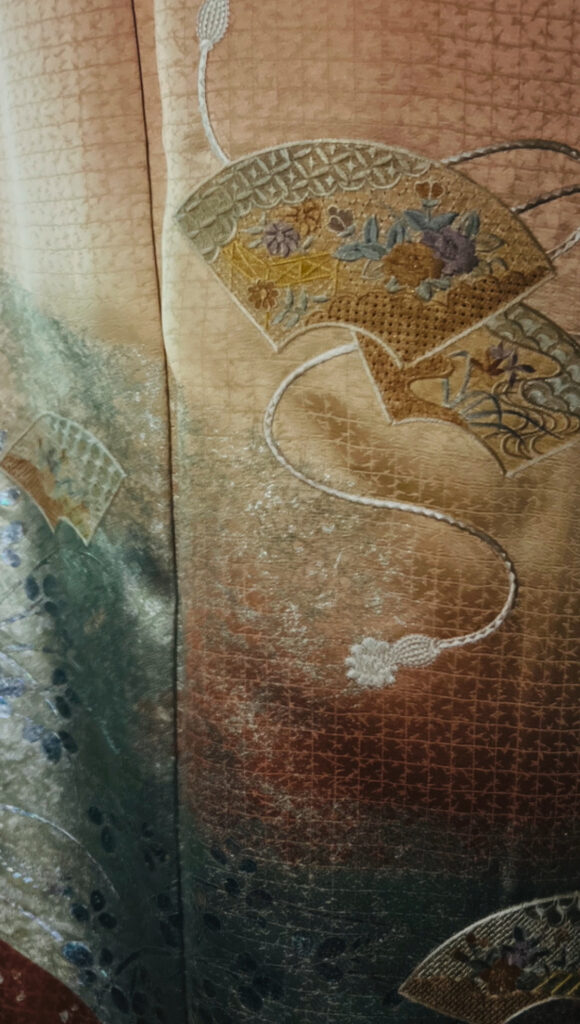 橙の訪問着の裾に描かれた扇文様の詳細。繊細な意匠が分かる写真