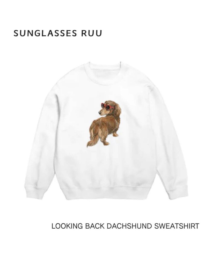 White sweatshirt featuring Ruu, a long-haired dachshund looking back in red sunglasses