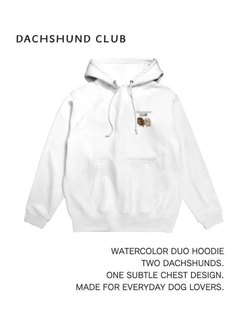 White hoodie with a small watercolor illustration of two miniature dachshunds and the DACHSHUND CLUB logo