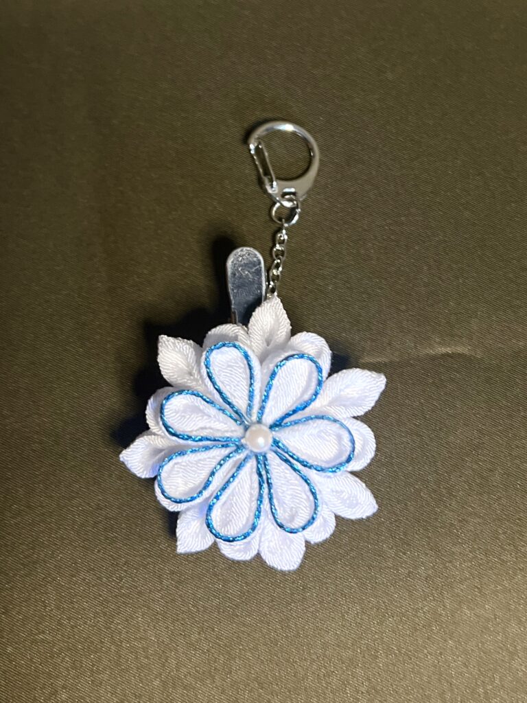 白い花びらにブルーのラインをあしらったつまみ細工2WAYチャーム「水花（みずか）」