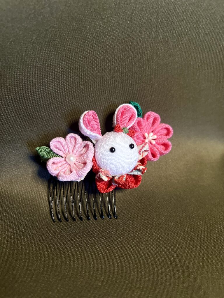 ピンクと赤の花に囲まれた白いうさぎのつまみ細工コーム