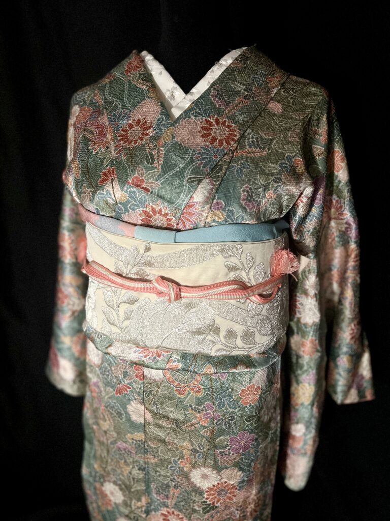 深緑の花柄正絹小紋に生成り系の袋帯と珊瑚色の帯締めを合わせた帯まわり